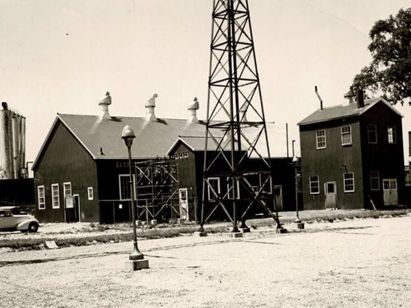 Row of houses behind an oil derrick in 1920's Toronto.